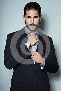 Handsome young business man in suit on grey background photo