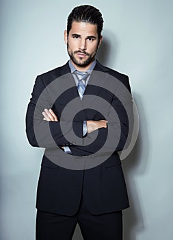 Handsome young business man in suit on grey background