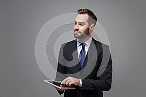Handsome young business man in suit shirt tie posing isolated on grey background. Achievement career wealth business