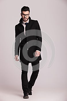 Handsome young business man wearing a long black coat