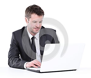 Handsome young business man workin on laptop. Isolated on white.