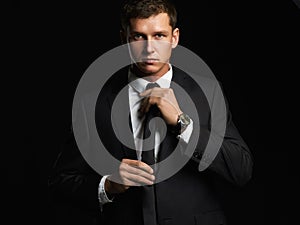 Handsome young businessman adjusting his tie. young man in suit