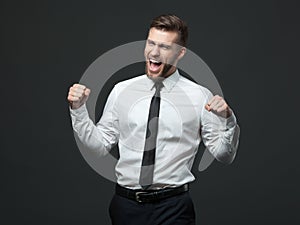 Handsome young businessman celebrating his success.