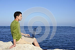 Handsome young businessman computer beach