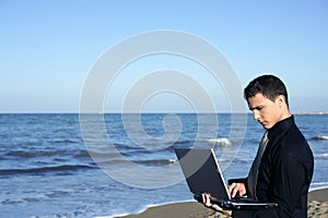 Handsome young businessman computer beach