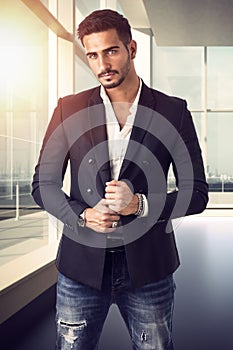 Handsome young businessman in office building, standing
