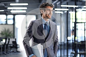 Handsome young businessman standing in modern office