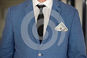 handsome young businessman in a stylish jacket from a suit with a large sum of dollars.