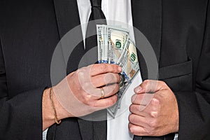 handsome young businessman in a stylish jacket from a suit with a large sum of dollars.