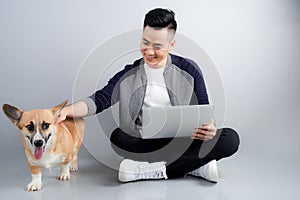 Handsome young businessman is using laptop while sitting with his dog on floor