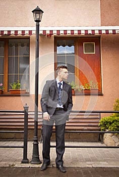 Handsome young businessman walking on city street in the morning going to work in office. Urban lifestyle of young profes