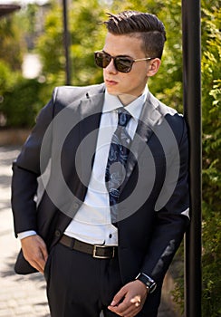 Handsome young businessman walking on city street in the morning going to work in office. Urban lifestyle of young profes