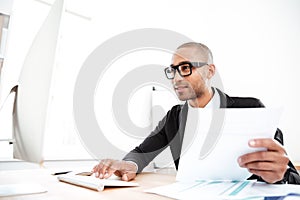 Handsome young businessman working with documents in office