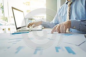 Handsome young businessman working with laptop while sitting on