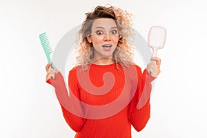 Beautiful woman holds two hairbrushes and smiles