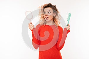 Beautiful woman holds two hairbrushes and smiles