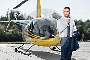 Handsome young CEO standing at a helipad