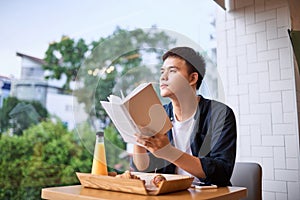 Handsome young designer writes creative graphic notes and making sketch in notebook