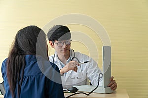 Handsome and young doctor giving a consultation to a patient and Explain medical information and check blood Pressure in doctor of