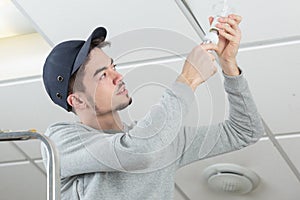 Handsome young electrician working at construction site