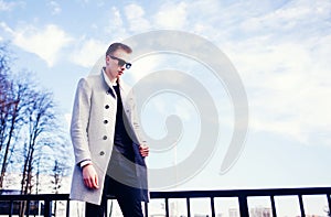 Handsome young fashion model posing on city