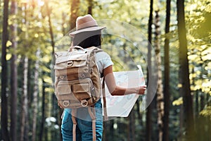 Handsome young girl traveling among trees in forest at sunset