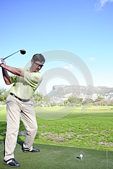 Handsome young golfer in action