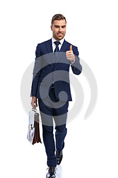 handsome young guy in elegant suit making thumbs up gesture