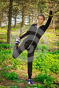 Handsome, young guy in a tracksuit plays sports in the park on the nature. Healthy lifestyle