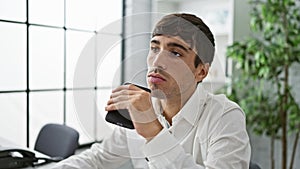 Handsome young hispanic man doubting work idea, seriously concentrating at his office job. portrait of an attractive business