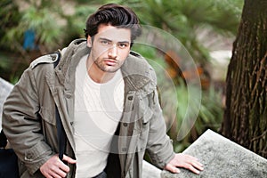 Handsome young italian man, stylish hair and coat outdoors