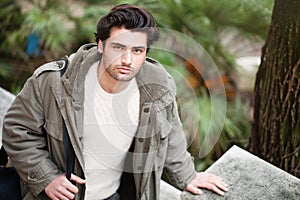 Handsome young italian man, stylish hair and coat outdoors photo
