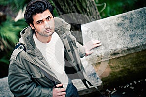 Handsome young italian man, stylish hair and coat outdoors