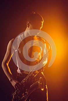 handsome young jazzman playing saxophone