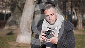 Handsome young male photographer filming video footage outside