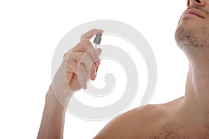 Handsome young male spray perfume on his skin photo