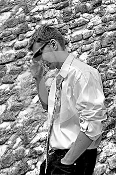 Handsome Young Male Wearing Sunglasses outdoors by Stone Wall