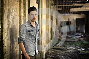 Handsome young man in abandoned, run down building