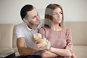 Handsome young man apologizing, presenting proud offended lady t