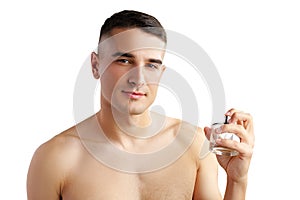 Handsome young man applying perfume on white background