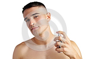 Handsome young man applying perfume on white background