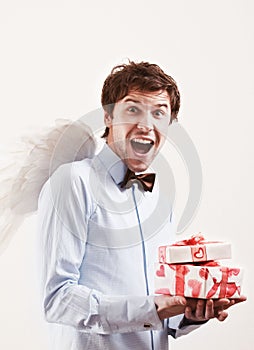 Handsome young man as cupid angel with presents