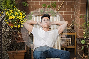 Handsome young man in balcony day-dreaming