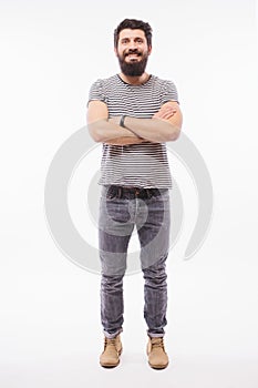 Handsome young man with beard full heigh with crossed hands