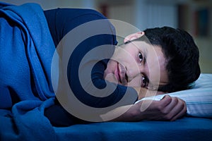 Handsome young man in bed with eyes opened suffering insomnia and sleep disorder thinking about his problem