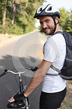 handsome young man biking in countryside