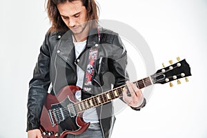 Handsome young man black leather jacket playing electric guitar