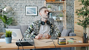 Handsome young man blogger recording audio talking in microphone in studio