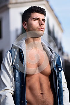 Handsome young man with blue eyes posing in urban background