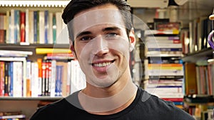 Handsome young man in bookstore smiling